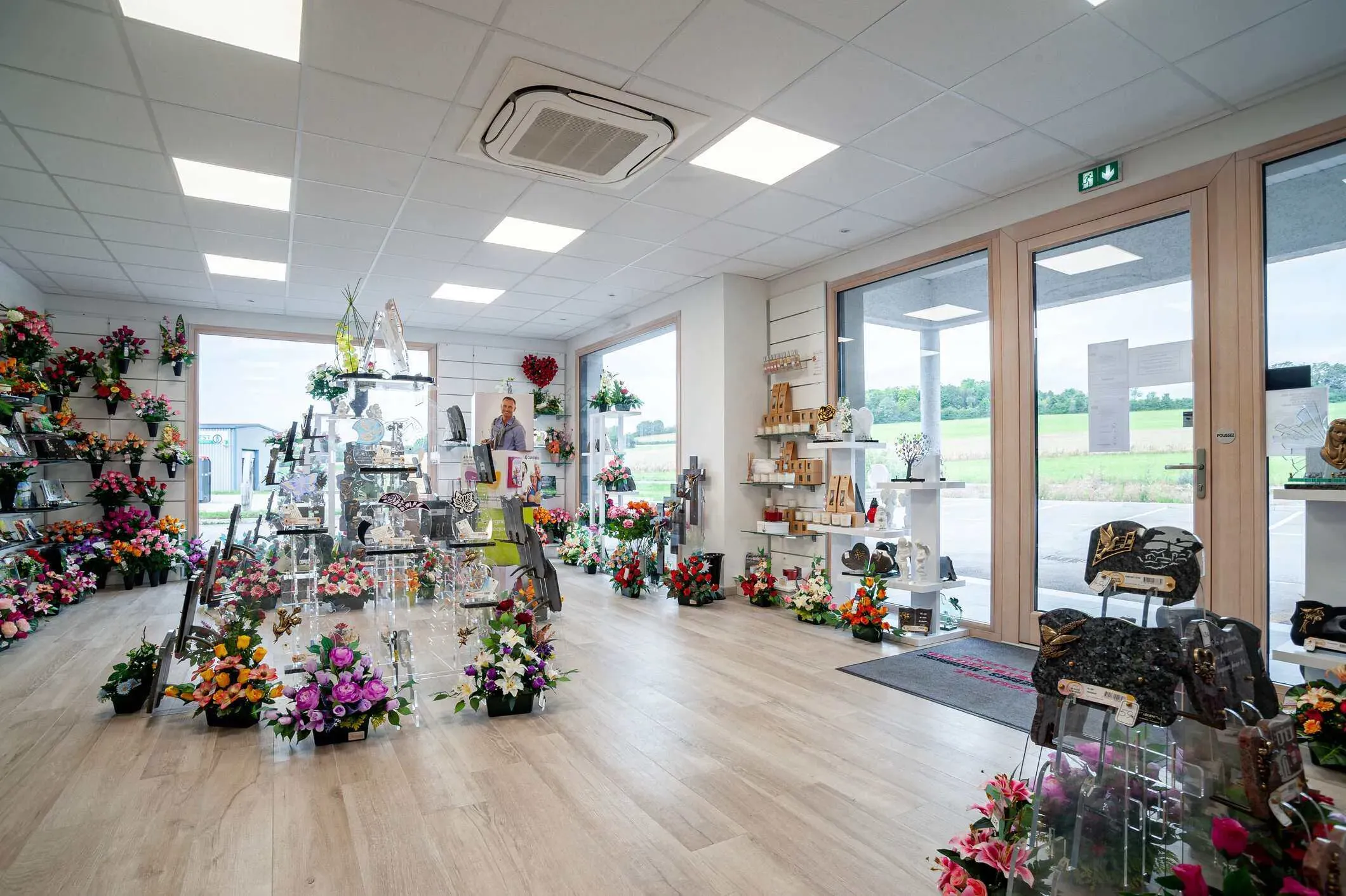 Boutique d'articles funéraires avec plaques et fleurs du souvenir exposées.