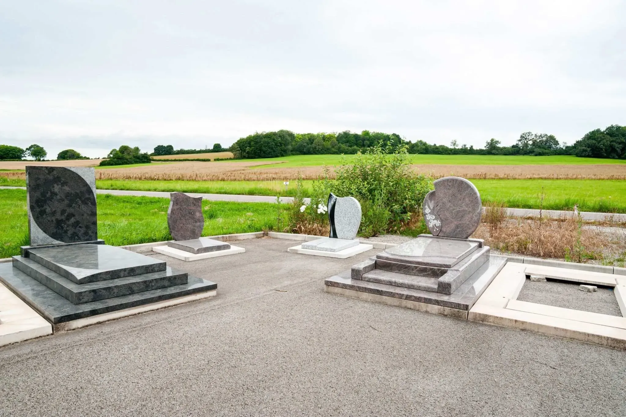 Différents modèles de monuments funéraires exposés en milieu naturel.
