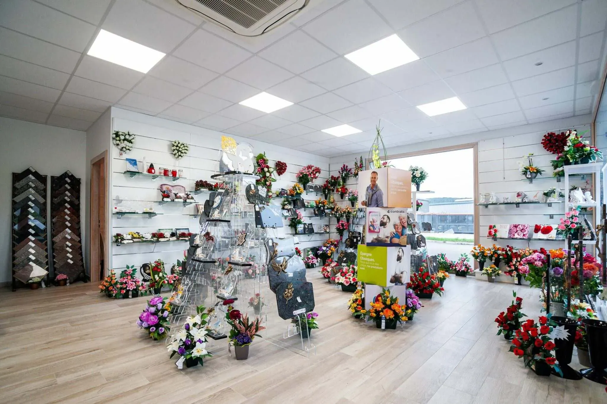 Magasin d'articles funéraires proposant plaques et compositions florales.